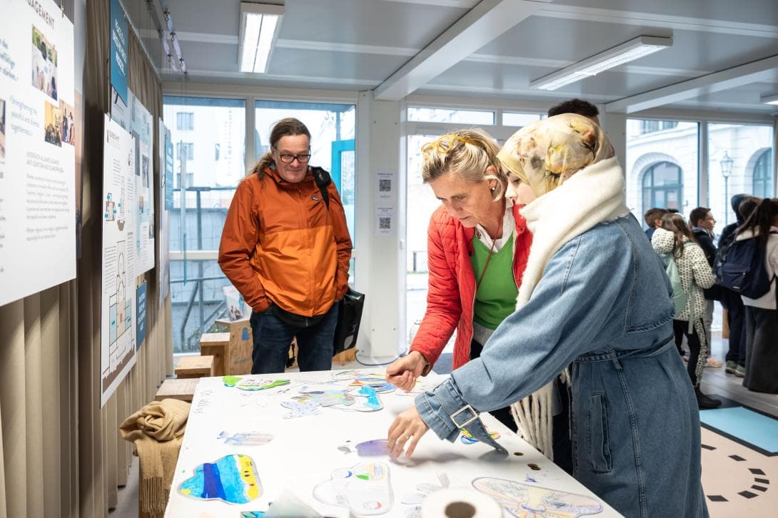 Die Künstlerin Andrea Wallgren bearbeitet die gezeichneten Friedensbotschaften der Kinder. In Hintergrund steht Andreas Funke vom Bezirksamt Mitte, das das Schulprogramm finanziert. .