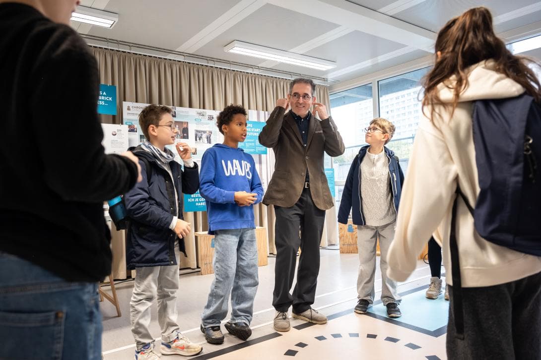 Osman Örs, Bildungsreferent, spielt mit Schülerinnen und Schülern ein Religionsquiz in der House of One-Box. 